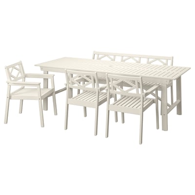 A BONDHOLMEN outdoor dining set in white with acacia wood and acrylic paint. It includes a rectangular table and six matching chairs.