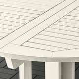 White acacia outdoor table with sleek, angled design and sturdy legs.