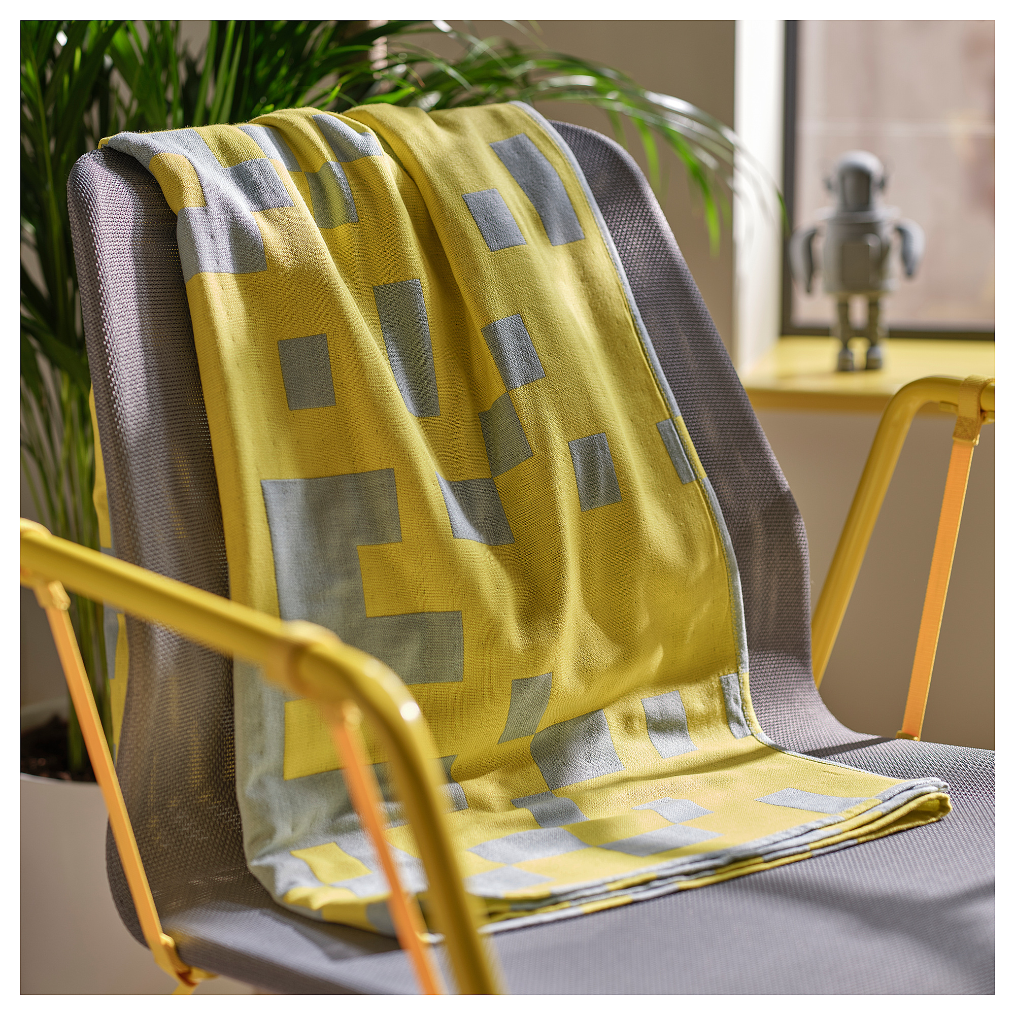 BRÄNNBOLL yellow blanket with gray squares on a gray chair, larger than the chair, soft, recycled polyester.