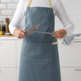 Person holding a knife sharpener in a kitchen.