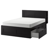 An ikea BRIMNES black bed with built-in storage drawers and a headboard.