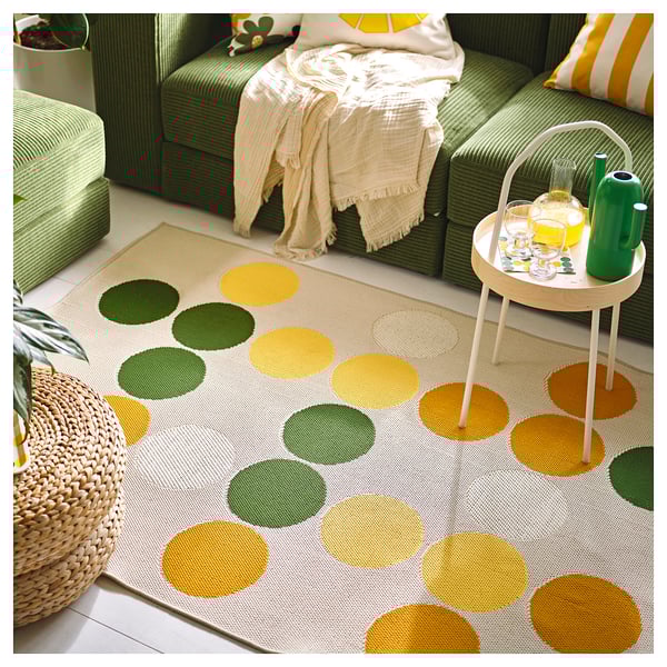 Bright polka-dot rug, green, round circles, on green furniture, modern design.