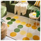 Bright polka-dot rug, green, round circles, on green furniture, modern design.