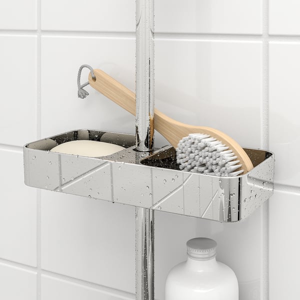 Metal shower shelf holds brush, soap, and bottle. Rests on rail, with adjustable height and drainage holes.
