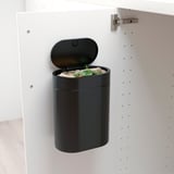 Black bin in white cabinet, open for organics, narrow-space friendly with press lid and bag handles.