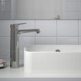 Modern chrome bathroom faucet with lever handle, saving water by cold start function.