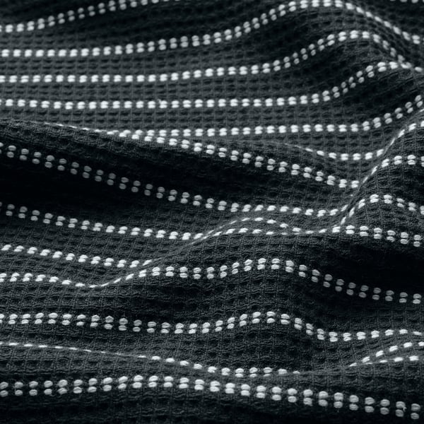 Black and white close-up of textured towel, showing waffle design details.