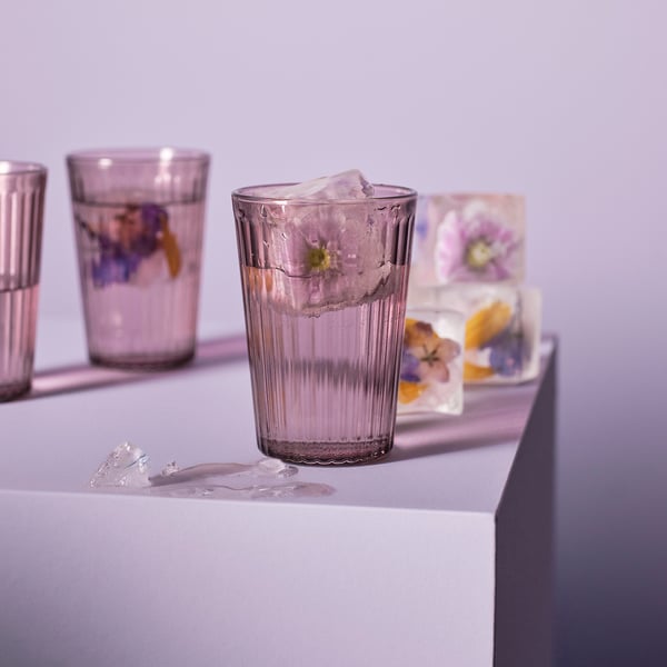 Three glasses: water, ice, flowers. One melting. Purple.