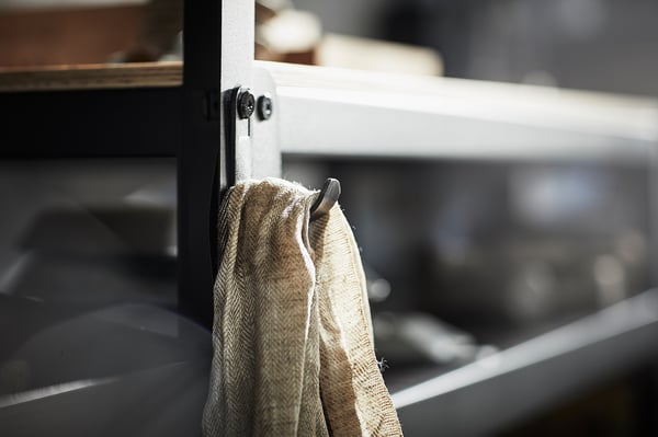 Black BROR hook holds gray towels on metal shelf, simple and sturdy.