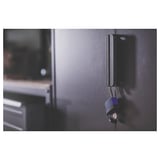 Black metal storage unit with lock, featuring two compartments. Industrial design with robust construction, mounted on a wall.