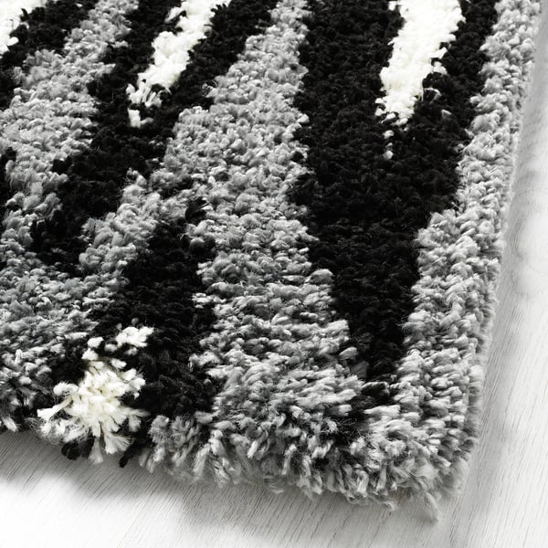 Fluffy black and white rug on a wooden floor.