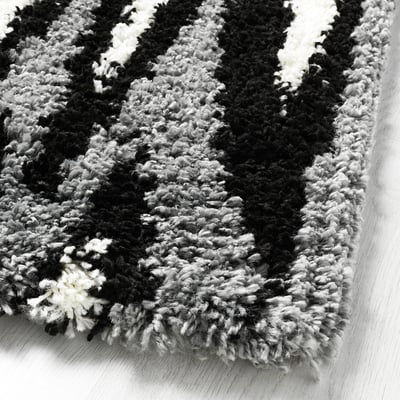 Fluffy black and white rug on a wooden floor.