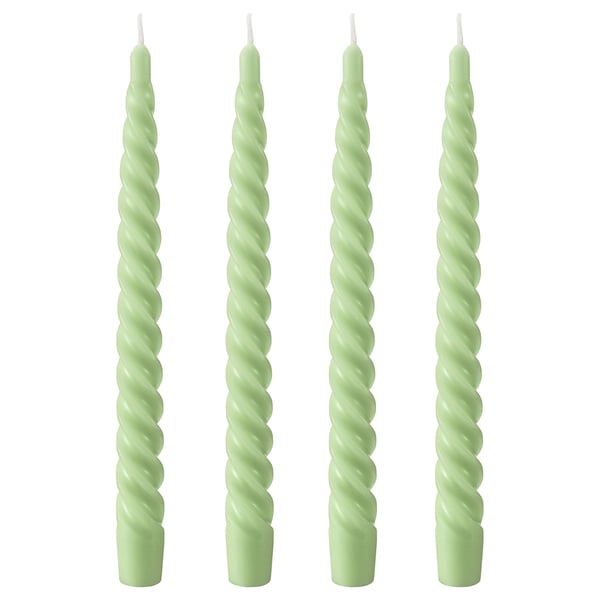 Four light green twisted candles, made of paraffin and plant-based wax, standing upright in a row.