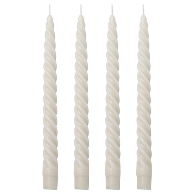 Four white spiral candles in a row. Made of paraffin and cotton. Tall, twisted design.