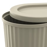Round, beige trash bin with lid and handle; one visible vertical stripe detail.