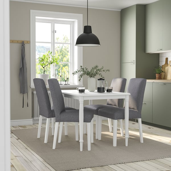 Modern dining set with white table, grey chairs, hanging lamp, and window.