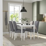 Modern dining set with white table, grey chairs, hanging lamp, and window.