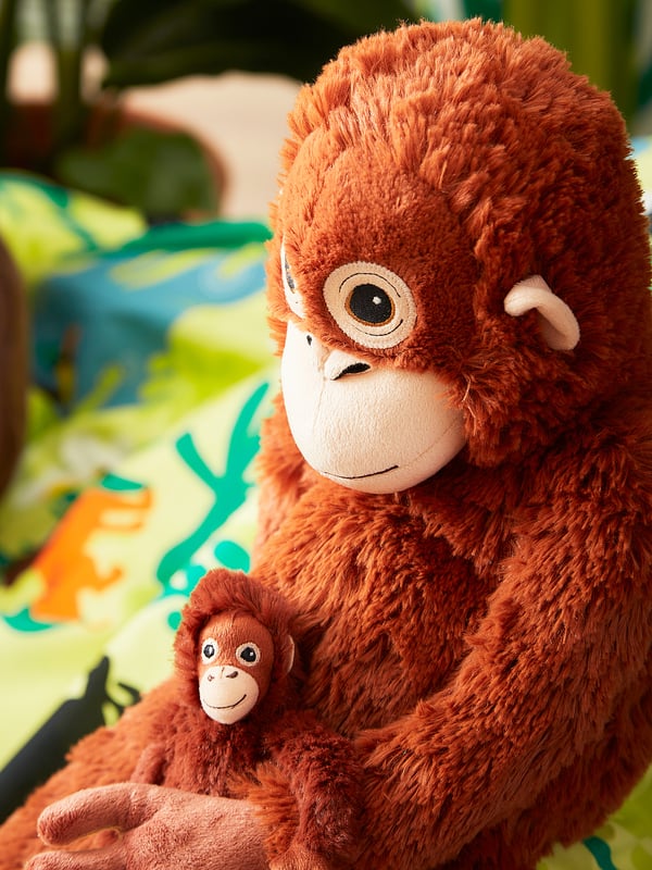 Two plush brown orangutan toys, adult holding baby, soft texture, friendly faces, perfect for cuddling and play.
