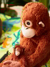 Two plush brown orangutan toys, adult holding baby, soft texture, friendly faces, perfect for cuddling and play.