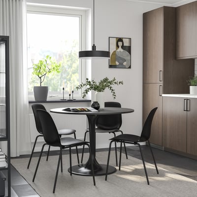Black DOCKSTA dining set with round table and chairs. Modern, metal-framed, compact kitchen nook.