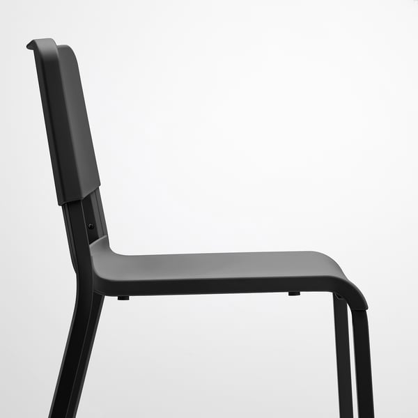 Modern black stacking chair, durable plastic seat and back, sturdy metal legs.