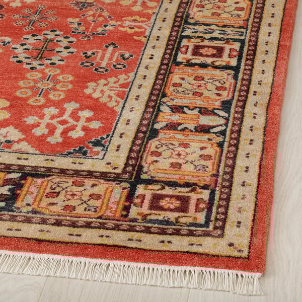 Vibrant, hand-knotted area rug with intricate floral designs. Rich reds, yellows, and beiges. High-quality wool and cotton.