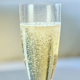 Clear glass flute filled with bubbly, non-alcoholic beverage, likely DRYCK BUBBEL PÄRON, showcasing its light golden hue.