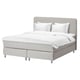 A modern DUNVIK bed in grey with white linens. It a headboard and upholstered sides, offering a clean and minimalist design.