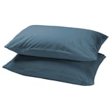 Stacked teal DVALA cotton pillowcases, rectangular.