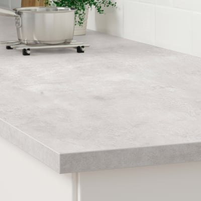 A modern kitchen countertop made of EKBACKEN in beige, displaying a smooth and sleek surface perfect for preparing meals.