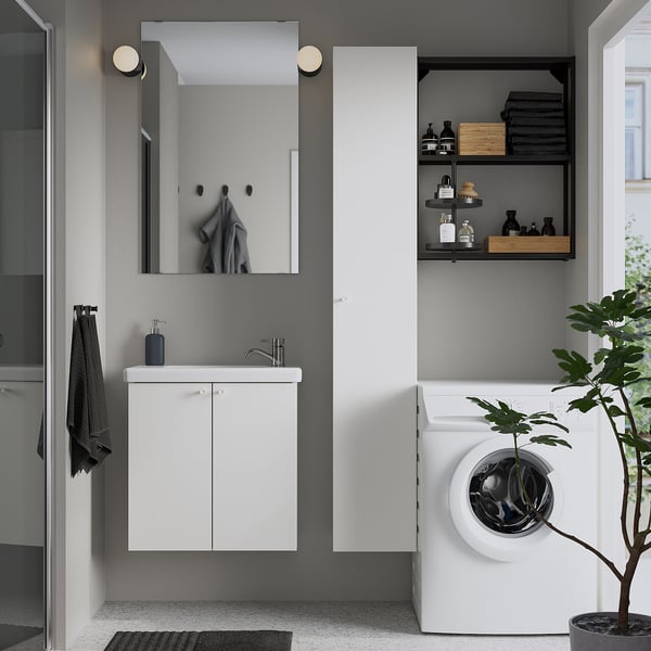 Modern bathroom with white floating cabinet, sink, mirror, and storage. Grey walls and black accents.