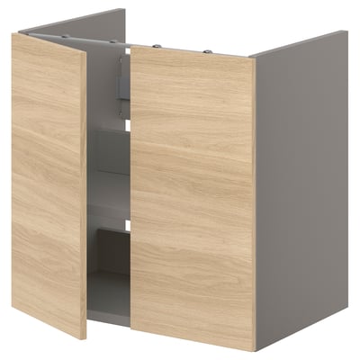 An ENHET light brown wooden bathroom cabinet with gray interior and shelves. Two doors are open, revealing storage space.
