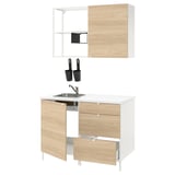 Modern kitchen setup with wooden fronts, white countertop, stainless steel sink, wall cabinets, and black accessories.