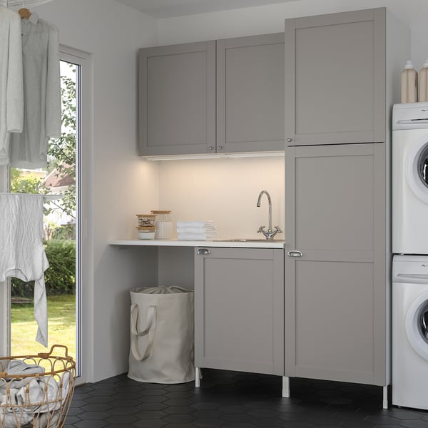 Modern grey laundry setup: ENHET. Sink, cabinets, washer. Tidy, efficient design.