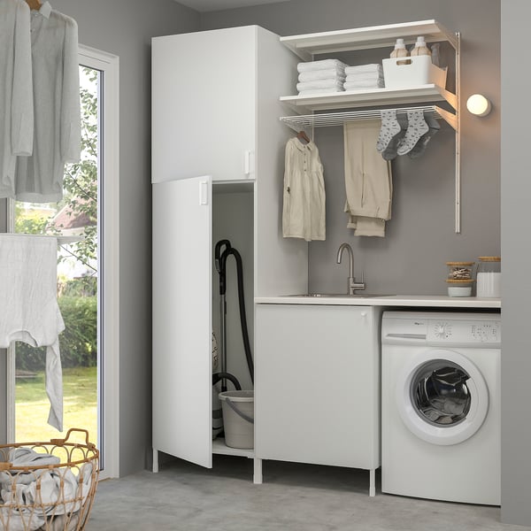 Modern white laundry setup with storage, sink, and dryer. Hangs clothes and stores supplies efficiently.