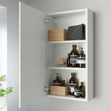 A modern bathroom cabinet with mirrored door open, revealing three shelves stocked with bottles, containers, and a hairbrush, mounted on a gray wall.