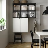 ENHET kitchen storage: open/closed cabinets in white/black, holding items, modern design with stool.