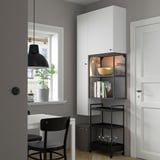 Modern living room with ENHET storage, white cabinets, black cart, lighting, and plant.