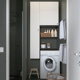Laundry room with ENHET cabinets, washing machine, and organized supplies.
