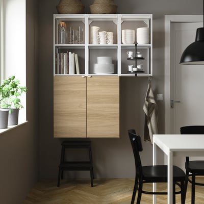 Modern kitchen with ENHET units, dishes, books, pendant light, chairs, stool. Wood floor, gray wall, 10-year guarantee.