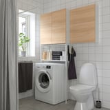 Modern bathroom ENHET storage combo, white washing machine, toilet, and wooden cabinets. Provides ample storage with open and closed shelves.