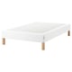 White espevar platform bed with wooden legs.