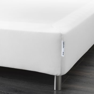 A white bed mattress base with removable cover, providing support and extra height.