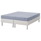 A white ESPEVÄR/VADSÖ bed with a blue mattress, supported by steel legs.