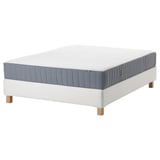 Displays a white espevär mattress on a valevåg white bed base. The mattress has blue and white vertical stripes, and the bed base has wooden legs.