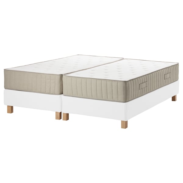Two beige mattresses, beige sides, on white adjustable bases with wooden legs.