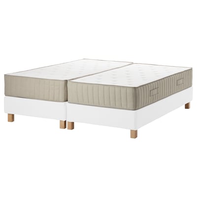 Two beige mattresses, beige sides, on white adjustable bases with wooden legs.