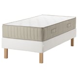 A modern white bed with an espevar base and vatnestrom mattress, featuring wooden legs and a quilted design.