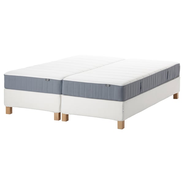 Two white mattresses on stand, blue edges, rectangular shape, wooden legs.