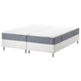 Two divided mattresses, white and grey, on a white platform bed.